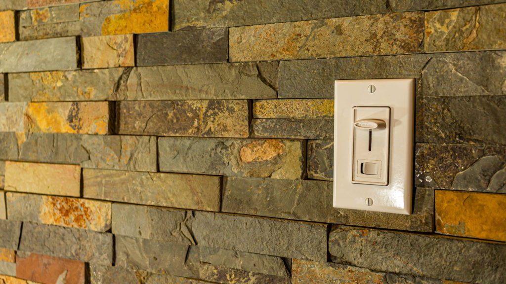 Dimmer Light Switch on a Stone Tiled Wall